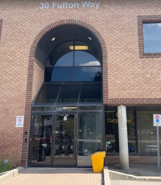 The main entrance at 30 Fulton Way: a brick archway over glass doors with an 8 on them